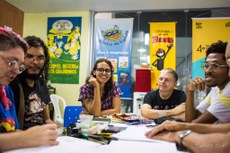 A chefe do Núcleo da Gibiteca Henfíl, Thaïs Gualberto, ladeada por quadrinistas durante uma das atividades regulares da Funesc