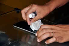 Técnicos em eletrônica orientam os usuários a higienizar os aparelhos eletrônicos com álcool em gel em um lenço de papel