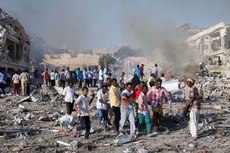 Civis socorrem feridos em meio aos escombros depois da explosão de caminhões-bomba, 237 já morreram